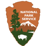 Logo of the National Park Service featuring a tree, mountain, and bison on a shield.