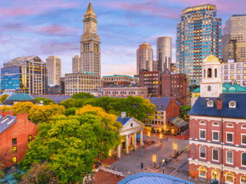 A vibrant cityscape featuring historical buildings and modern skyscrapers, likely Boston with Faneuil Hall and the Custom House Tower.