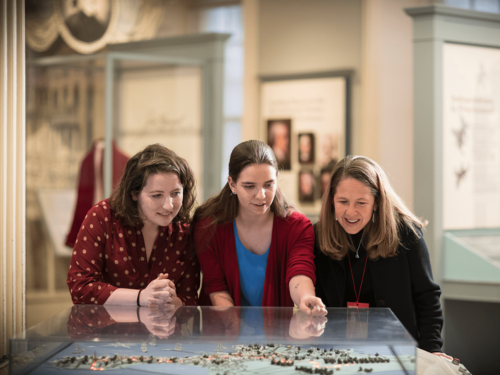 People are observing an exhibit in a museum setting.