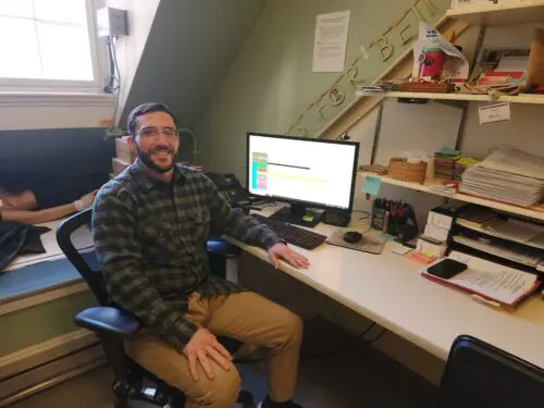 Man sitting at his desk looking at the camera