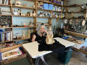 Artist Janet Cordell in her studio with her beautiful handmade creation, the Polly Sumner doll reproduction, April 2023. Photo courtesy of Lori Erickson.