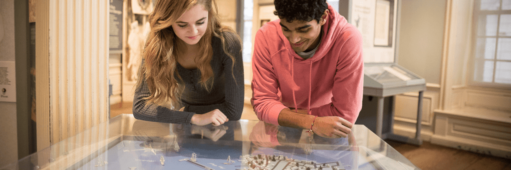 Two teens looking at a map of 18th century Boston.