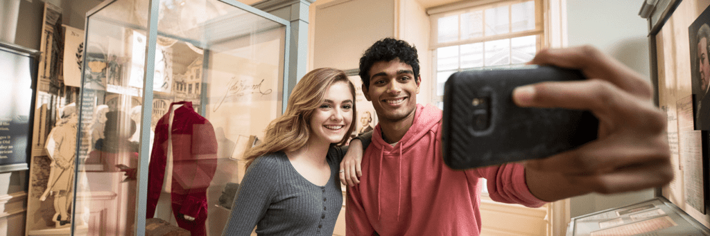 Two teens take a selfie in a gallery at the Old State Hosue.