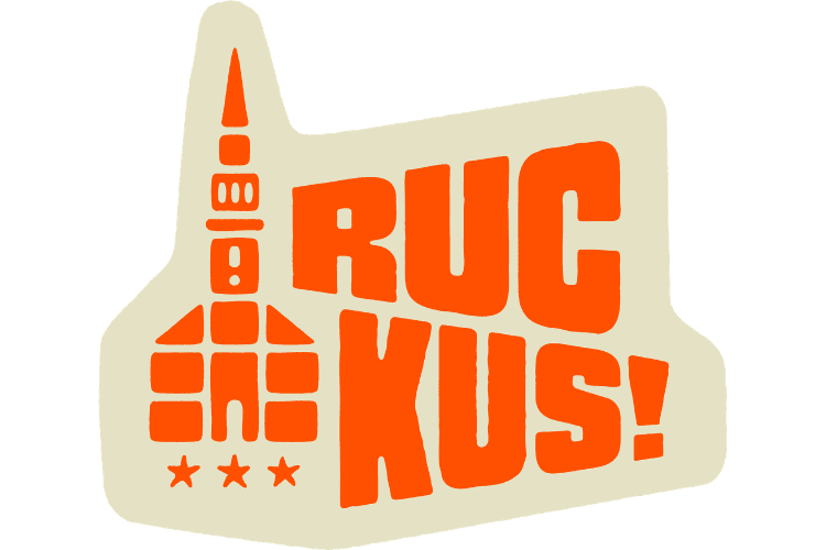 Logo featuring "Ruckus" in all caps followed by an exclamation point, to the right of a block-print styled illustration of a building with a steeple, both in red-orange against a beige background